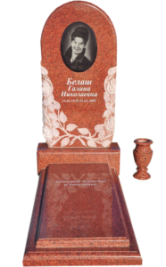 Памятник из красного гранита с цветами в Геленджике